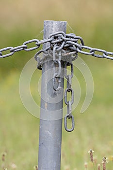 Industrial chain attached to a galvanised fence post