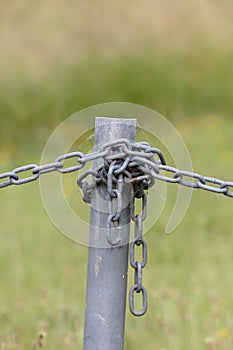 Industrial chain attached to a galvanised fence post