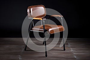 industrial chair with a leather or faux-leather seat, metal legs and wooden armrests