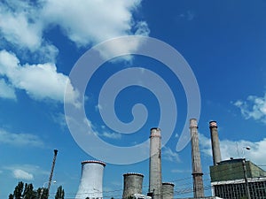 Industrial chimney against blue  cloudy sky