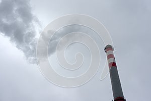 Industrial chimney against cloudy sky