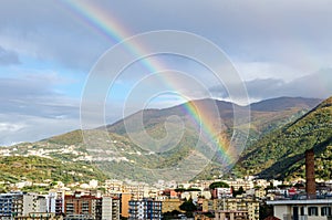 industrial chimney with rainbow in a small town