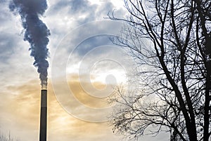 Industrial chimney, thermal power plant, pollution in the air, steam cooling tower in Graz, Styria region, Austria, at sunset