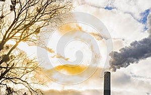 Industrial chimney, thermal power plant, pollution in the air, steam cooling tower in Graz, Styria region, Austria, at sunset
