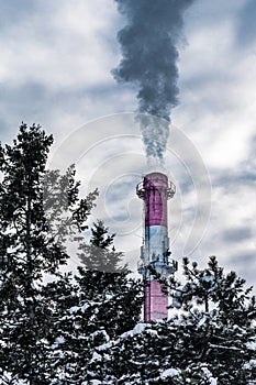 Industrial chimneys with dramatic smoke in nature on cold winter day