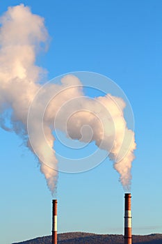 Industrial chimneys with smoke on a background of blue sky, conservation and protection of nature and climate, concept