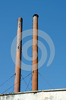 Industrial chimneys top against blue sky