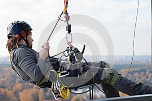 Industrial climber is hanging on ropes