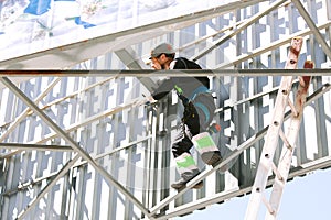 Industrial climber in helmet and overall working on height.