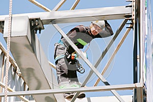 Industrial climber in helmet and overall working on height.