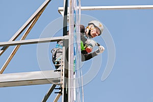 Industrial climber in helmet and overall working on height.