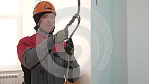 Industrial climber knits a rope for lifting equipment. a worker in a protective helmet knits a knot on a rope.