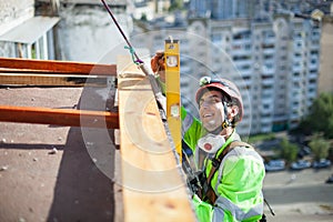 Industrial climber measuring with level tube during construction works