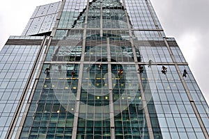 Industrial climber washes glass on the facade of a skyscraper