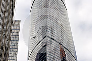 Industrial climber washes glass on the facade of a skyscraper