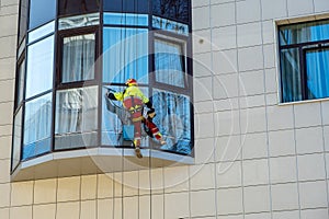 An industrial climber washes the window of a high-rise residential building
