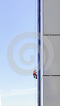 Industrial climber washes Windows on high skyscraper