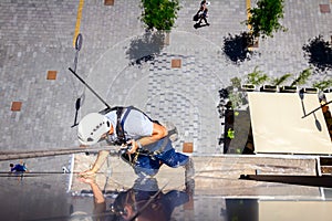 Industrial climber is washing, cleaning facade of a modern office building photo