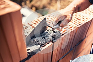 Industrial - Construction bricklayer worker building walls with bricks, mortar and putty knife