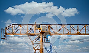 Industrial construction cranes and building silhouettes over sun at sunrise