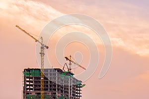 Industrial construction cranes and building before sunrise.Industrial construction crane over building site