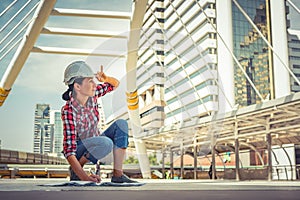 Industrial construction engineer holding pen and safety helmet engineering working on building outside. Engineering tools and