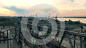 Industrial construction in the port with two engineers walking along it