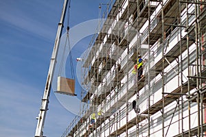 industrial construction site is equipped with metal scaffolding and a crane, which is used to lift heavy materials to higher