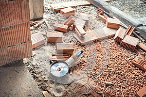 Industrial construction site tools, angle grinder used for cutting bricks at building renovation, reconstruction