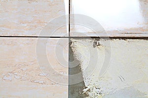 Industrial construction worker installing small ceramic tiles on bathroom walls and applying mortar with trowel