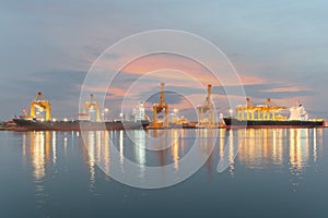 Industrial Container Cargo freight ship with working crane bridge in shipyard at dusk for Logistic Import Export background