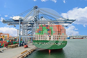 Industrial Container Cargo freight ship with working crane bridge in shipyard for Logistic Import Export background