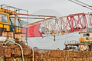 Industrial crane on deck of rusty abandoned barge