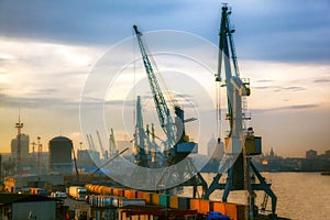 Industrial cranes loading freight containers for cargo ships.