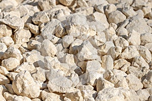 Industrial crushed stone close-up. Bulk material for road construction or laying utilities. Rubble under sunlight and