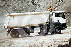 Industrial dumper trucks working on construction site, loading and unloading gravel and earth. heavy duty machinery activity