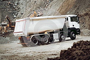 Industrial dumper trucks working on construction site, loading and unloading gravel and earth. heavy duty machinery activity