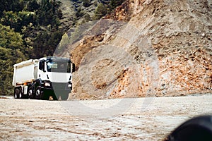 Industrial dumper trucks working on highway construction site, loading and unloading gravel and earth. heavy duty machinery activi