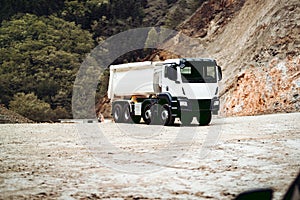 Industrial dumper trucks working on highway construction site, loading and unloading gravel and earth. heavy duty machinery activi