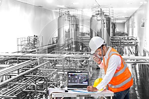 Industrial engineer checking machine status with laptop computer