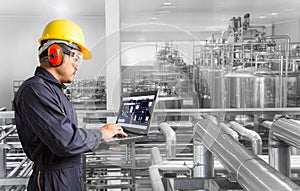 Industrial engineer checking machine status with laptop computer