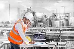 Industrial engineer checking machine status with laptop computer