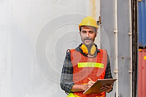 Industrial engineer in hard hat containers box background, Dock worker man holding clipboard checklist at containers cargo,