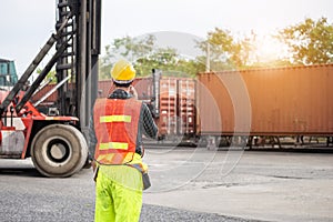 Industrial engineer in hard hat containers box background, Dock worker man talks on two-way radio with holding clipboard checklist