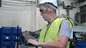 Industrial engineer with hard hat working with laptop at factory