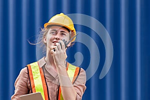 Industrial engineer in hardhat control loading containers box background, Dock worker holding tablet smartphone at containers