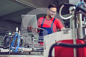 Industrial engineer with laptop in a  industrial manufacture factory working.