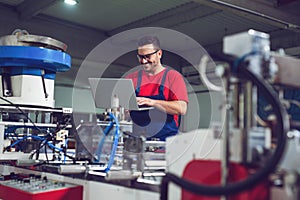 Industrial engineer with laptop in a  industrial manufacture factory working.