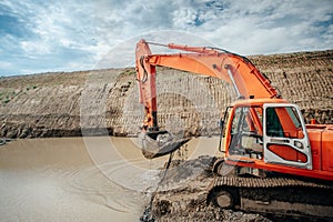 Industrial engineer working with excavator during highway construction site, loading dumper trucks and building viaduct and bridge