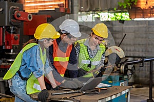 Industrial engineers have consult with femal colleagues while using laptop